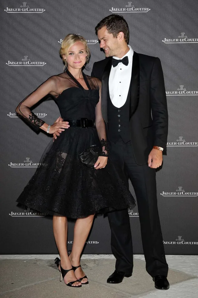 A couple in formal attire at a Jaeger-LeCoultre event; the woman in a black dress and the man in a tuxedo.