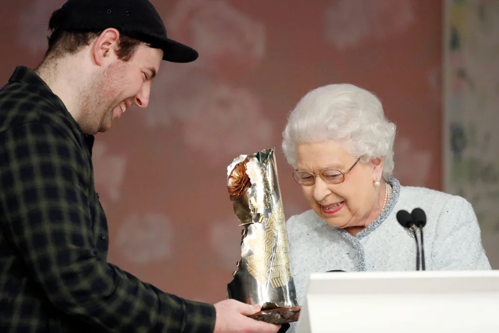 Queen Elizabeth II (R) awards designer Richard Quinn (L) the inaugural Queen Elizabeth II award for British Design during London Fashion Week February 2018