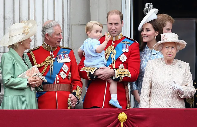 A group of elegantly dressed individuals stand on a balcony, including a young child in blue being held by an adult.