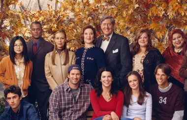 Group of people posing outdoors with autumn leaves in the background.