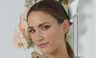 ```html
<img src="imagename.jpg" alt="Woman with flowers in hair posing against a floral background." />
```