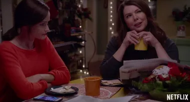 Two women sitting at a table, one holding a yellow mug, with holiday decorations in the background, Netflix logo visible.