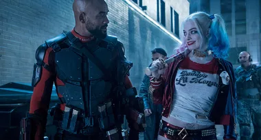 Harley Quinn and Deadshot walking in an alley at night, Harley holding a bat, both in costume from "Suicide Squad."