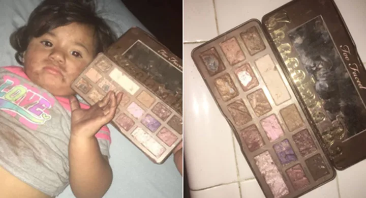 Child lying down, face smeared with makeup, holding an open Too Faced eyeshadow palette.