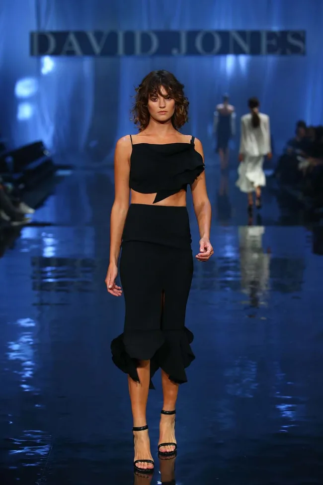 Model in a black outfit walks down the runway at a David Jones fashion show.