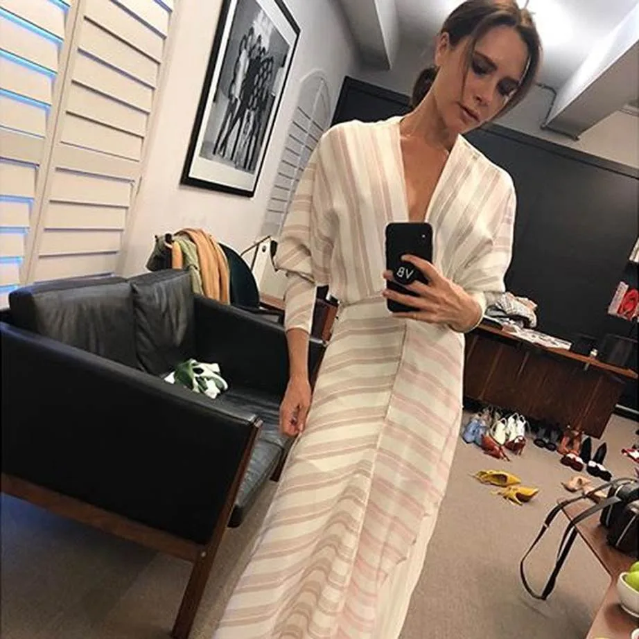 Victoria Beckham in a dress that shows off her slim figure.