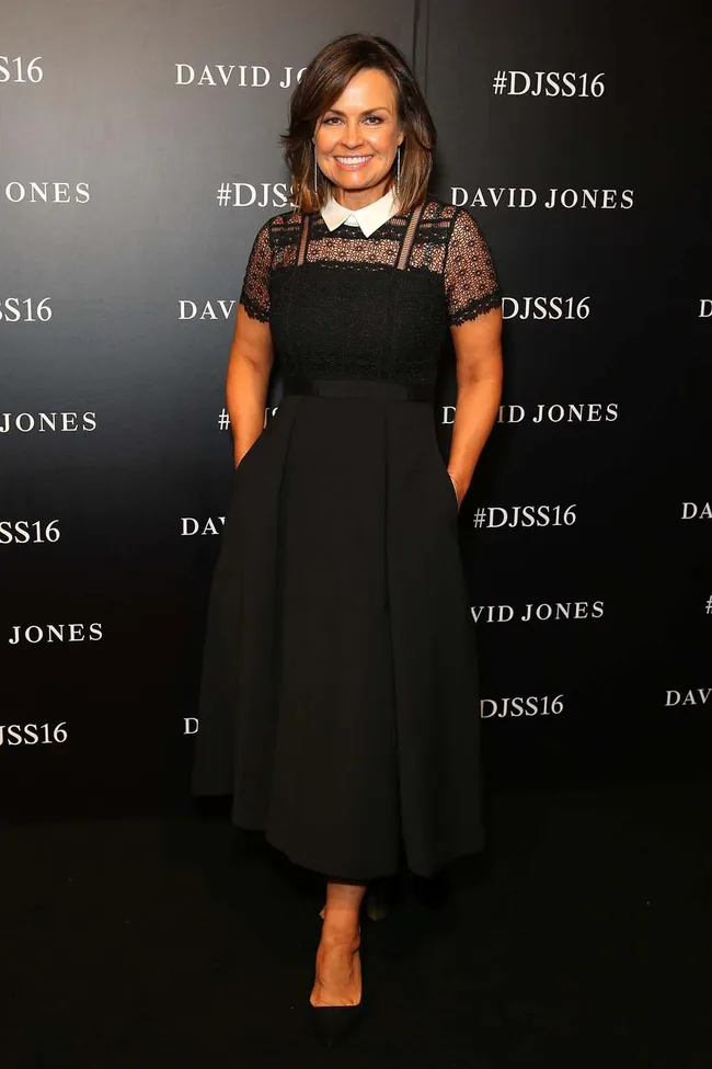 A person in a black dress stands in front of a David Jones backdrop at the DJSS16 event.