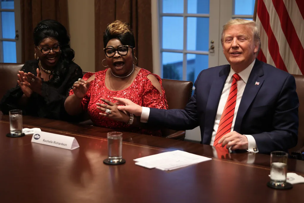 U.S. President Donald Trump (R) listens as Lynette 'Diamond' Hardaway (L) and Rochelle 'Silk' Richardson praise him during a news conference and meeting with African American supporters in the Cabinet Room at the White House February 27, 2020