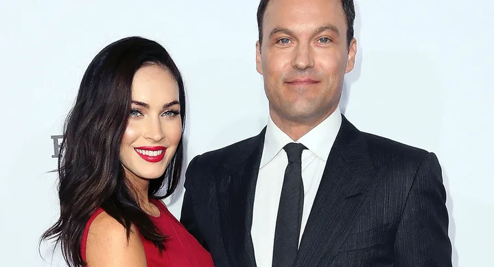 Two people smiling at a formal event; woman in red dress, man in dark suit and tie.