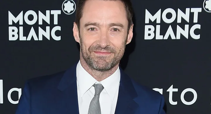 "Man in a suit smiling at a Montblanc event backdrop."