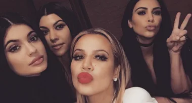 Group selfie of four women, one making a peace sign, all facing the camera and puckering their lips.