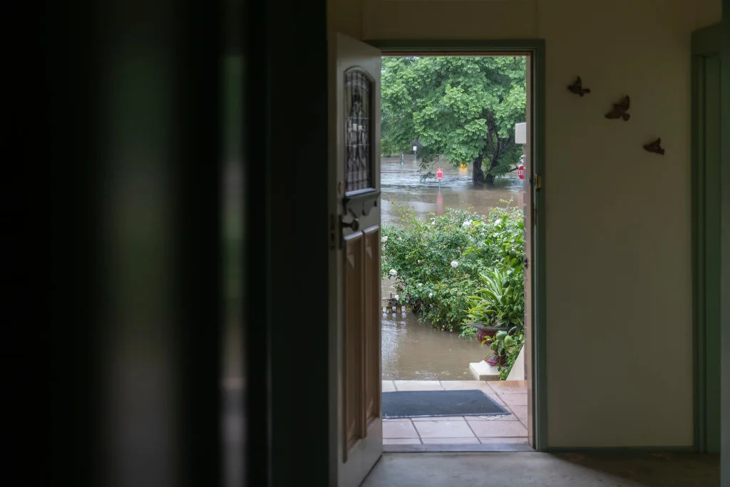The house of Windsor resident Kelly Miller is seen as flood waters reach her workplace, a 100 year old property near the Windsor CBD