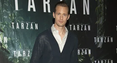 A person at "La Leyenda de Tarzan" event, standing in front of the event backdrop.