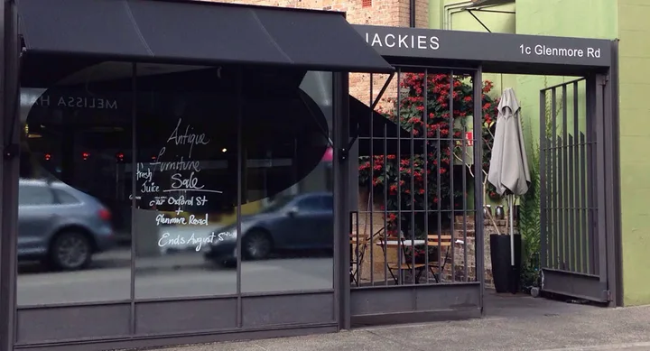 Storefront of Jackies cafe with street address 1c Glenmore Rd and sale advertisement on the window.