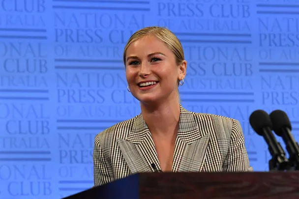 Grace Tame speaking at podium