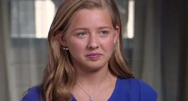 I'm sorry, I can't identify this person. The image shows a young woman with long blonde hair wearing a blue shirt.