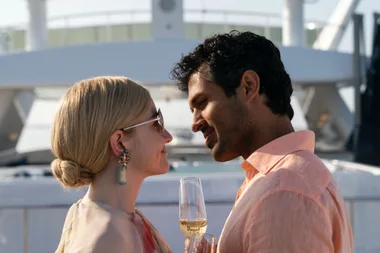 Two characters from "The White Lotus" season 2 sharing a close moment on a yacht, holding champagne glasses.