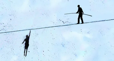 Visual of two silhouetted figures on a tightrope, one hanging and the other balancing with a pole, against a blue background.