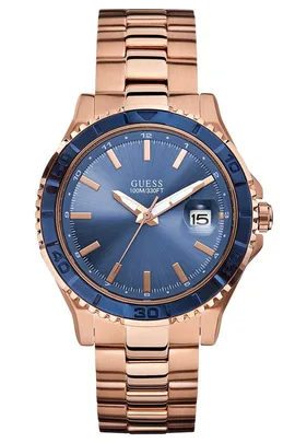 Rose gold Guess watch with a blue face, date display, and metal bracelet.