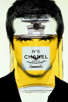 Person's face inside Chanel No. 5 perfume bottle, blending creativity and branding.