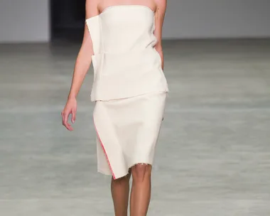 Model walking Calvin Klein Collection runway in an off-white, strapless dress during Spring/Summer 2014 fashion show.