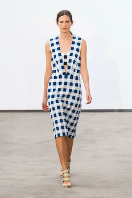 Model in blue and white checkered dress walking on a minimalist runway, showcasing Derek Lam Spring/Summer 2014 collection.