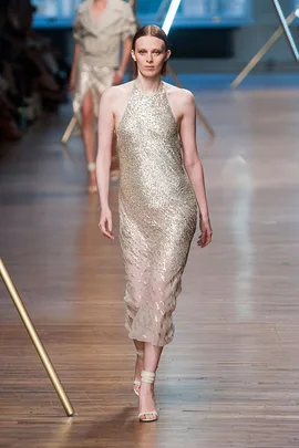 Model wearing a shimmering gold halter dress on the runway at Jason Wu SS14 fashion show.