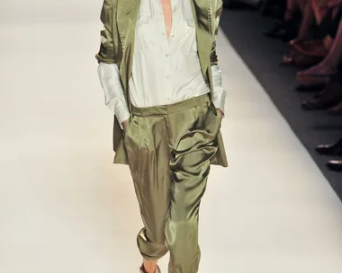 Model walks runway in olive silk suit and gold sandals at Rachel Zoe SS14 fashion show.