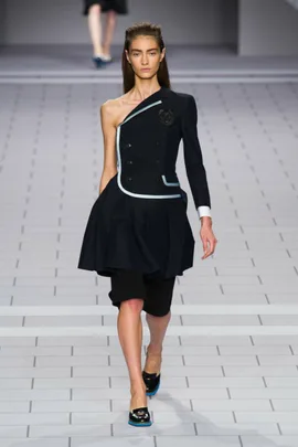 Model walks runway in asymmetrical black dress with light blue trim, featuring one sleeve, for Viktor & Rolf SS14 collection.