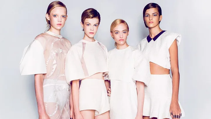 Four models in white, futuristic outfits by Alice McCall, posing against a plain backdrop.