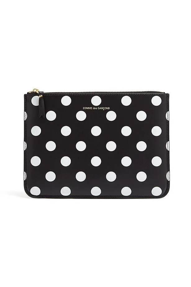 Black Comme des Garçons clutch with white polka dots and a gold zipper.