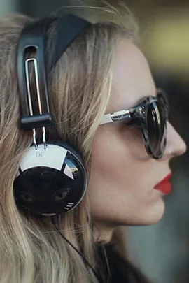 Woman with blonde hair wearing cat-themed headphones and sunglasses.