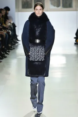 Model on runway wearing navy coat with fur trim, patterned detail, and tailored pants at Balenciaga Fall/Winter 2014-15.