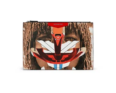 A Givenchy clutch with a tribal-inspired abstract face design in red, white, and blue over a background of dreadlocks.