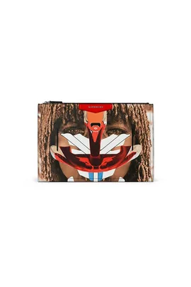 A Givenchy clutch with a tribal-inspired abstract face design in red, white, and blue over a background of dreadlocks.