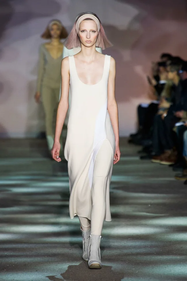 Model walking in Marc Jacobs Fall 2014 runway show, wearing a white dress and headband.