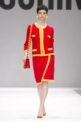 Model on runway in a red and yellow ensemble with matching accessories, Moschino AW14/15.