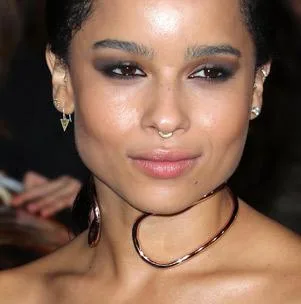 A person wearing a unique gold choker and earrings with smokey eye makeup at a formal event.