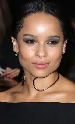 A person wearing a unique gold choker and earrings with smokey eye makeup at a formal event.