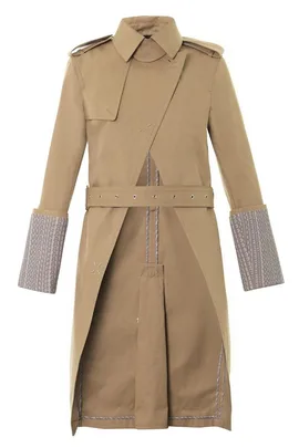 Tan long trench coat with asymmetric front, epaulets, belted waist, and patterned cuff detailing.