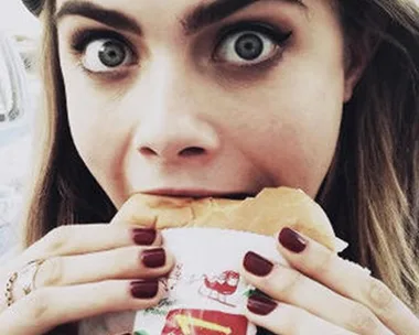 Cara Delevingne eating a burger