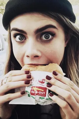 Cara Delevingne eating a burger