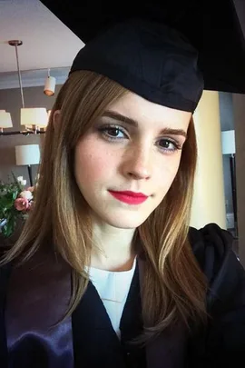 A young woman wearing a graduation cap and gown, smiling for a selfie. (Emma Watson graduates from Brown University)