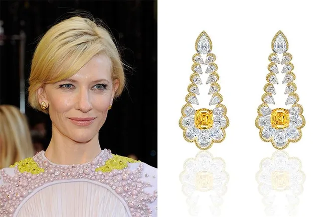 A person with short blonde hair in a beaded dress and two ornate yellow diamond earrings.