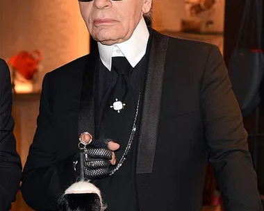 Karl Lagerfeld with his bag charm