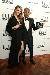 Two people pose on the red carpet at the Elle Style Awards 2014, one holding a trophy.