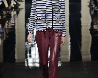 Model walks the runway in a houndstooth jacket and burgundy leather pants at Christopher Kane SS15 fashion show.