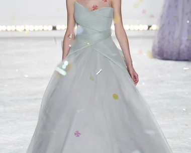 Model in a strapless, light grey gown with tulle skirt walking runway, floral appliqués on bodice, Monique Lhuillier SS15.