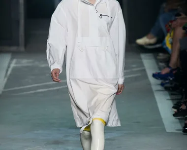 Model walks runway in white outfit with yellow boots at Marc by Marc Jacobs SS15 show.