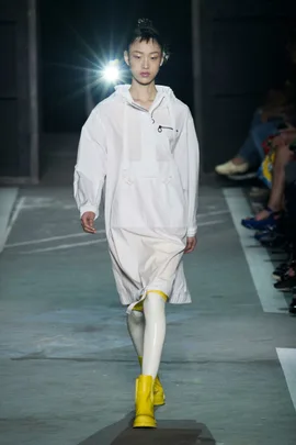 Model walks runway in white outfit with yellow boots at Marc by Marc Jacobs SS15 show.